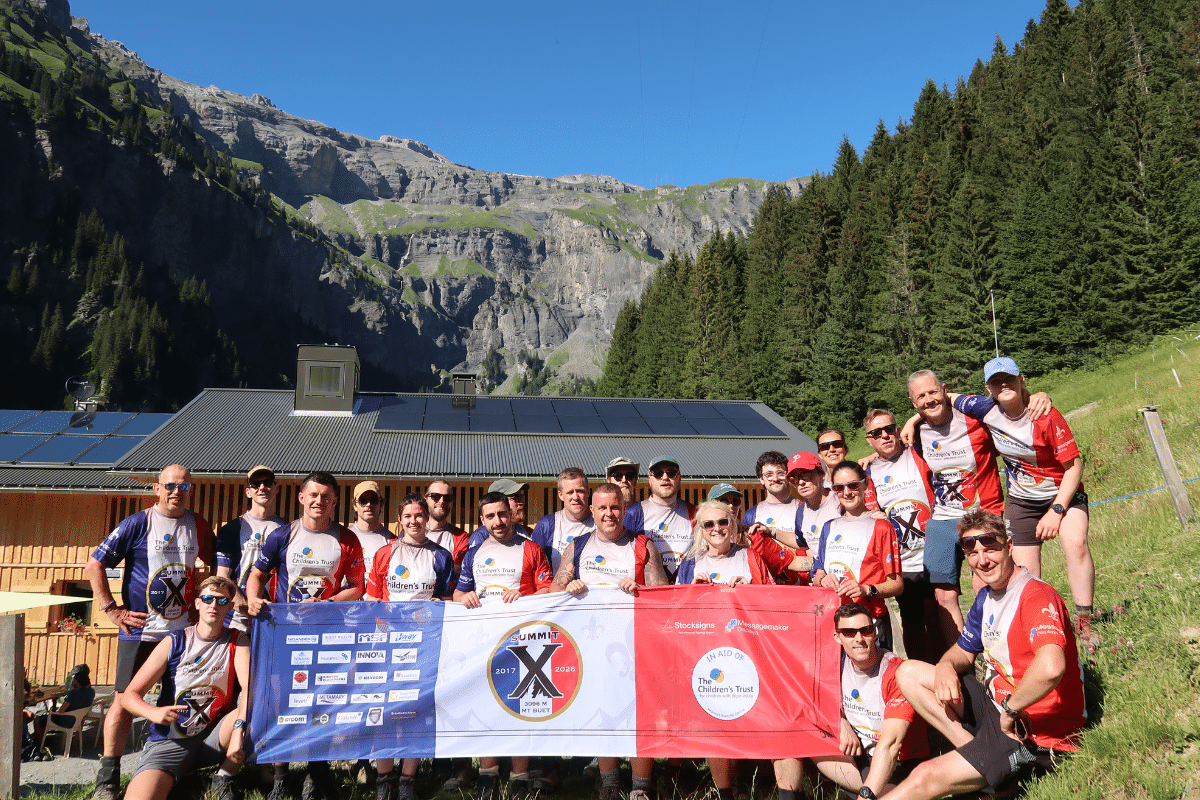Day One Completed Day One Completed- Photo outside the refugee with the banner with the mountains in the background